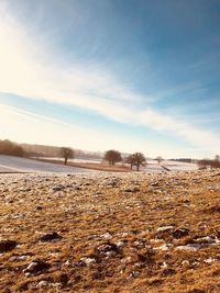 Scenic view of snow covered land against sky