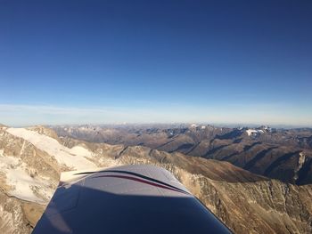 Aerial view of mountains against blue sky