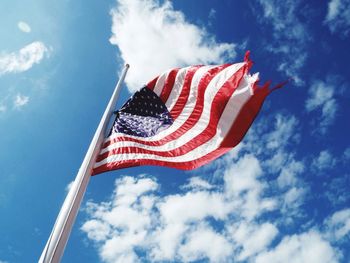 Low angle view of american flag against blue sky