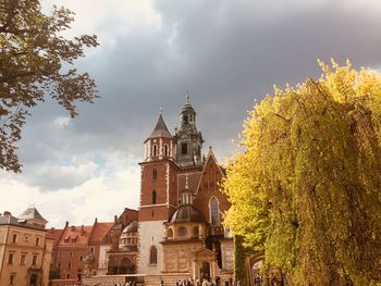 Low angle view of trees and buildings against sky