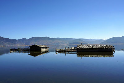 Lifeguard hut in lake against clear blue sky