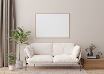 Empty horizontal picture frame on cream wall in modern living room. mock up interior 