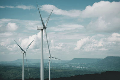 Wind turbines on land against sky