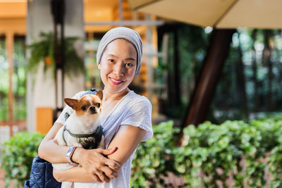 Portrait of young woman holding cat