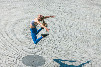 Full length of woman jumping on road