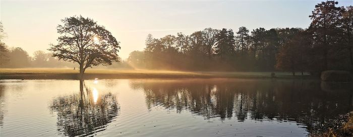 Scenic view of lake against sky at sunset