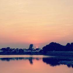 Scenic view of lake against orange sky