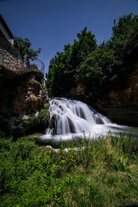 Scenic view of waterfall against trees
