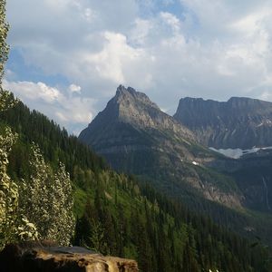 Scenic view of mountains at glacier national park against cloudy sky