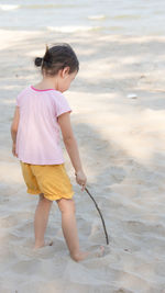 Cute baby asian girl, little preschooler child playing on white sand beach in summer time.