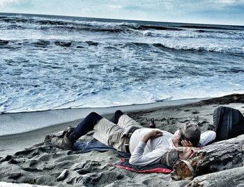 Rear view of woman sitting on beach