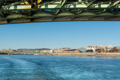 Bridge over river against buildings in city