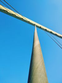 Low angle view of tolerance bridge cables against blue sky