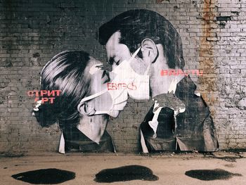 People standing against graffiti wall