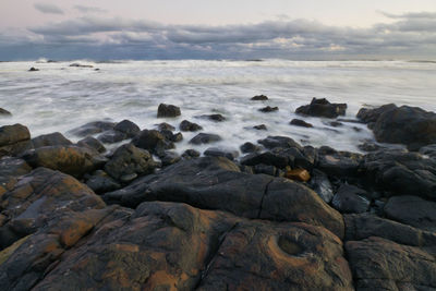 Rocks in sea against sky