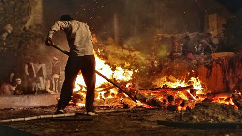 High angle view of man standing by bonfire