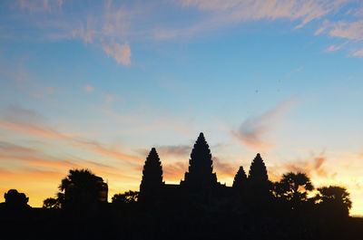 Silhouette of temple against cloudy sky