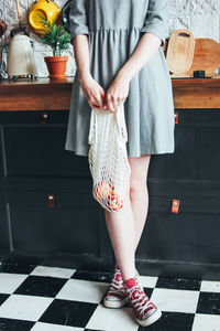 Low section of woman standing in kitchen