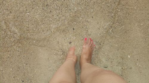 Low section of woman on sand