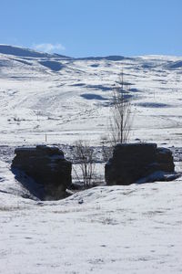 Scenic view of snow covered field against sky