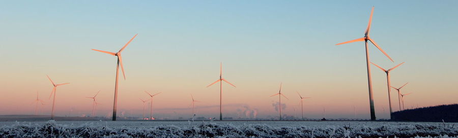 Wind turbines in sea against sky