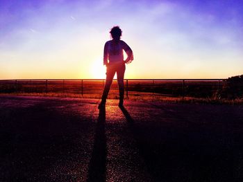 Man standing on soccer field at sunset