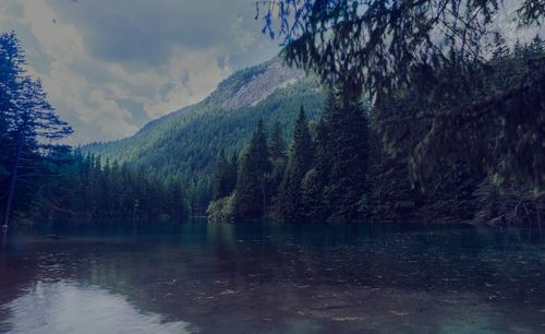 Scenic view of lake by mountains against sky