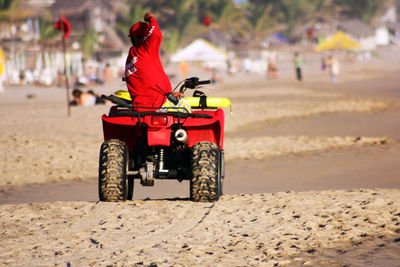 Rear view of man on quadbike at sandy beach