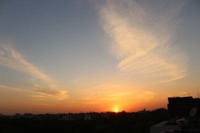 Silhouette cityscape against sky during sunset