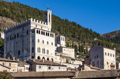 Buildings in city against clear blue sky