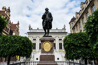 Low angle view of statue against building in city