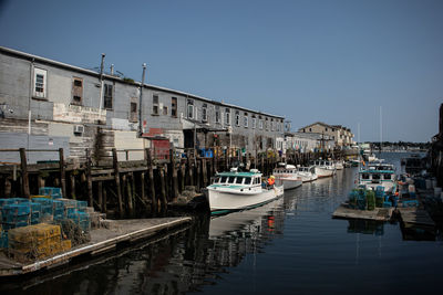 Boats moored in canal against buildings in city