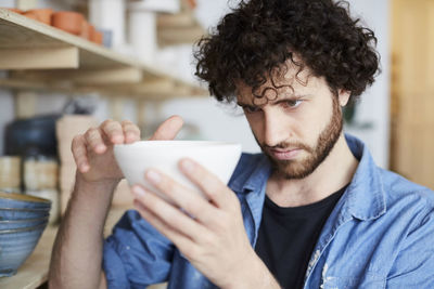 Man examining bowl in pottery class