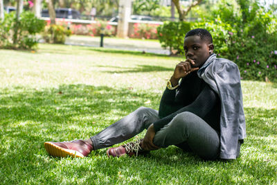Side view of man sitting on field