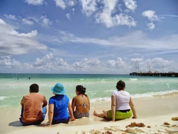 Rear view of people sitting on beach