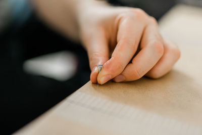 Cropped hand of woman writing in book