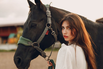 Close-up of young woman with horse