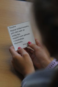 Midsection of woman holding text on paper