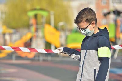 Close-up of boy wearing mask standing outdoors