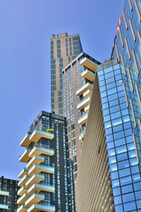 Low angle view of modern buildings against clear blue sky