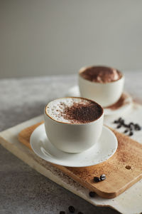 Close-up of coffee cup on cutting board