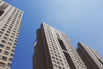 Low angle view of modern buildings against clear blue sky