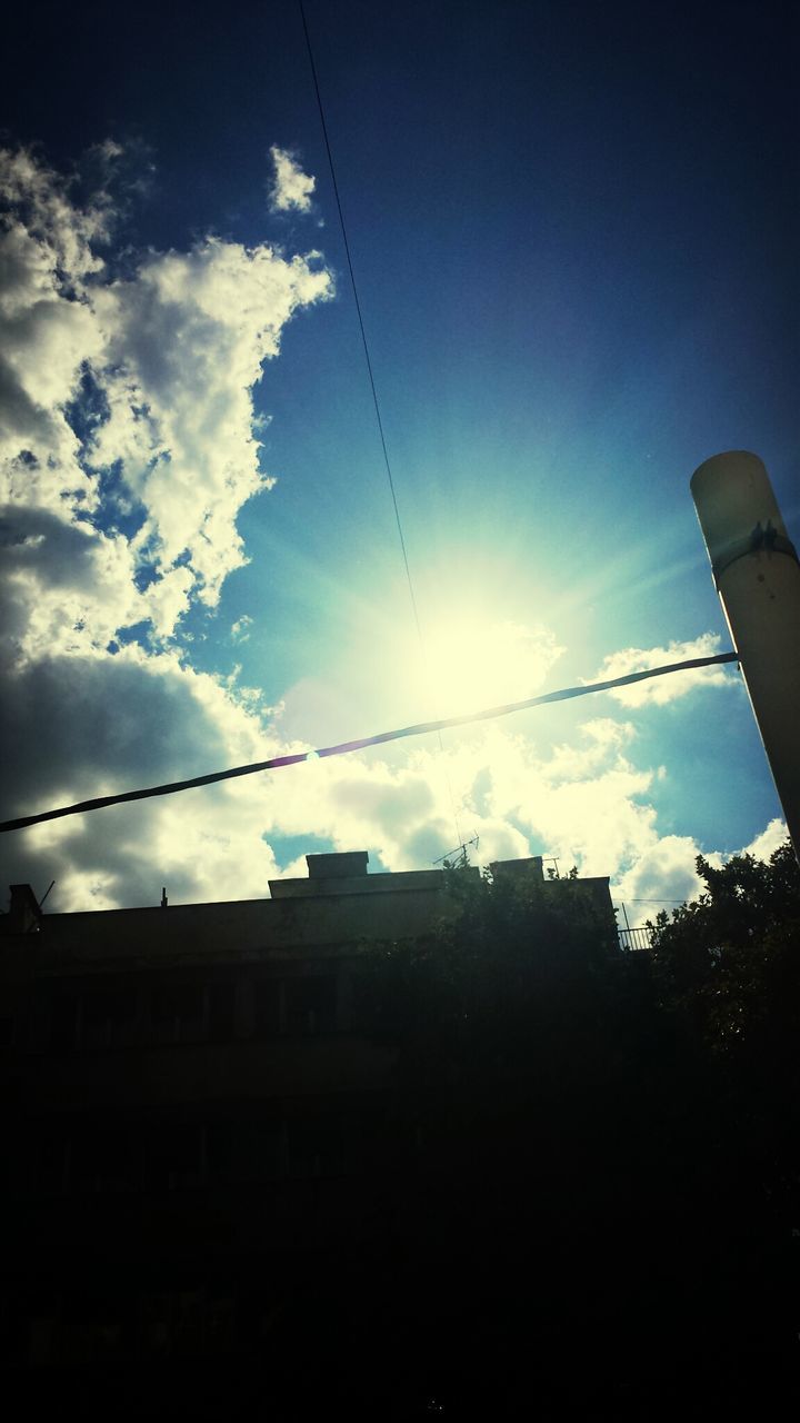 power line, low angle view, sky, built structure, architecture, cable, electricity pylon, electricity, building exterior, sun, sunlight, silhouette, blue, power supply, vapor trail, sunbeam, power cable, connection, fuel and power generation, cloud - sky
