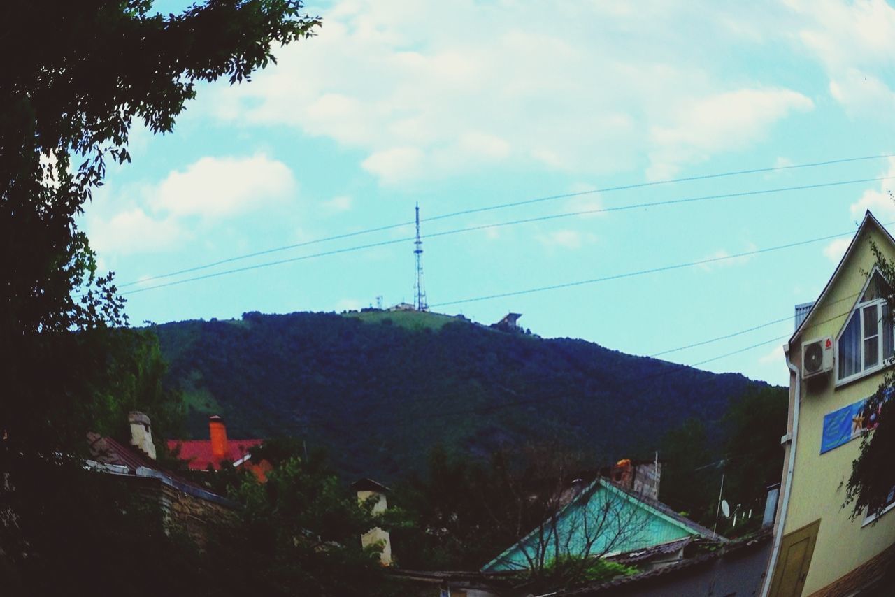 building exterior, sky, architecture, built structure, power line, house, cloud - sky, cable, electricity pylon, residential structure, tree, cloud, residential building, connection, mountain, cloudy, town, electricity, power supply, outdoors