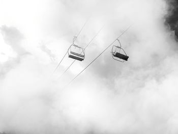 Low angle view of overhead cable car against sky