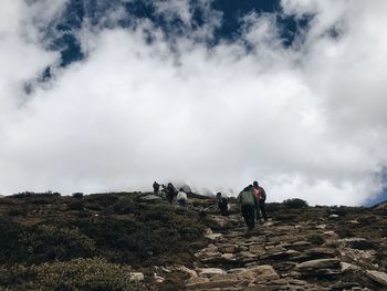 People on arid landscape against sky