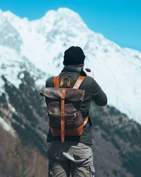 Rear view of man looking at mountain against sky