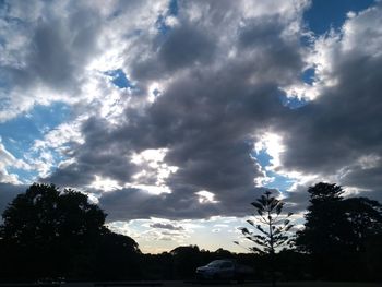 Silhouette of trees against cloudy sky