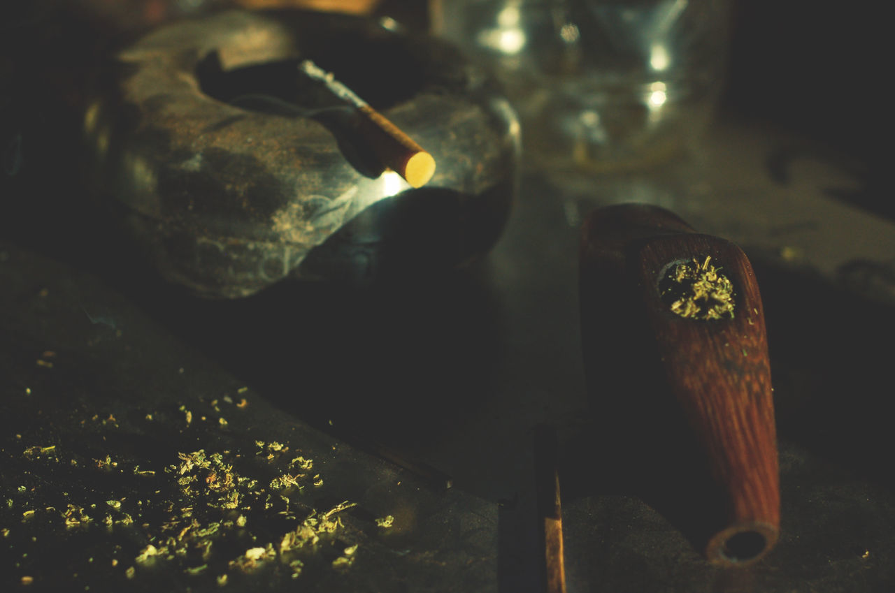 HIGH ANGLE VIEW OF CIGARETTE ON TABLE WITH WINE