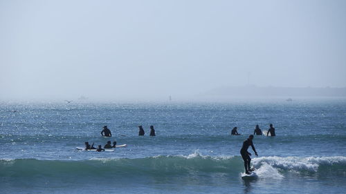 People surfboarding in sea